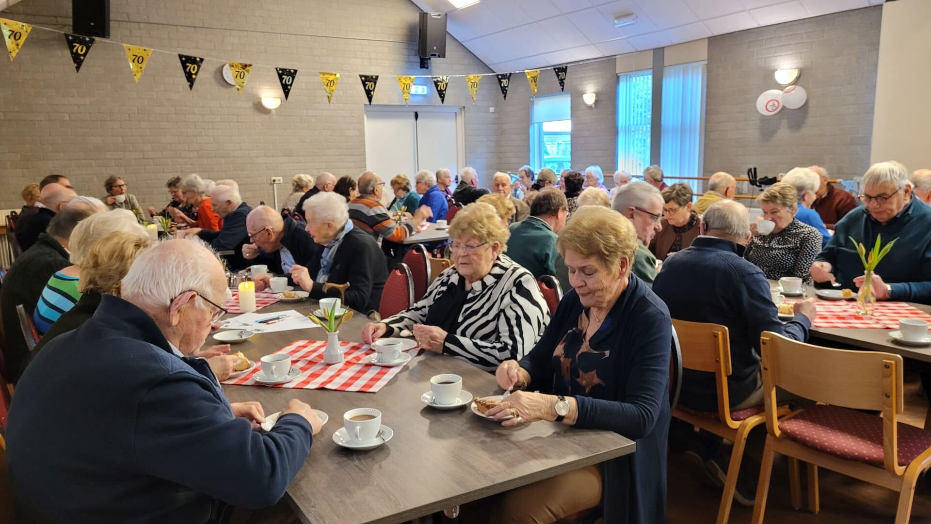 KBO-leden genieten van koffie/ thee en vlaai tijdens de viering van het zeventigjarig bestaan in Joffershof. 