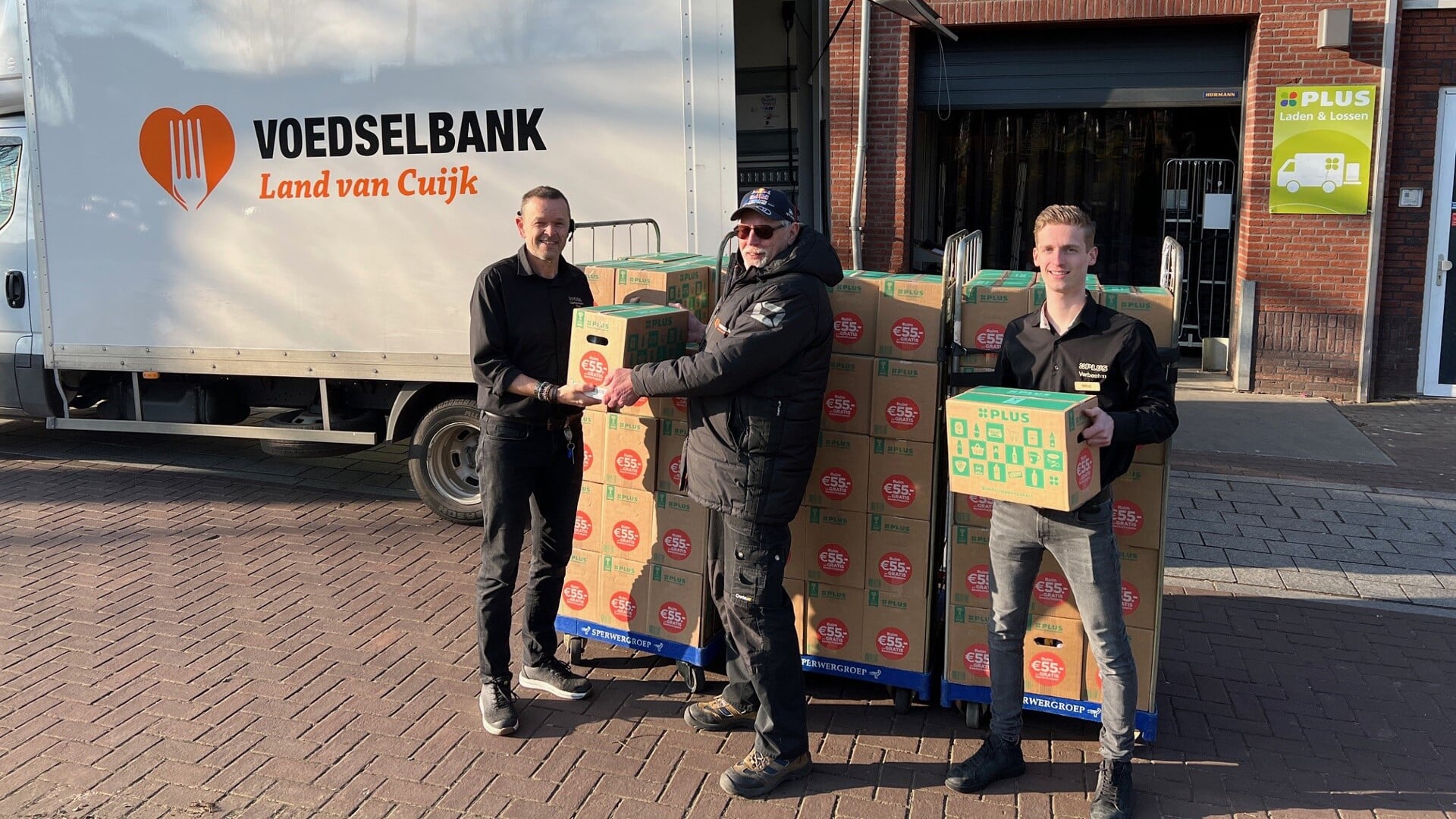 Ton en Niels van PLUS Verbeeten overhandigden de pakketten aan de vrijwilligers van Voedselbank Land van Cuijk