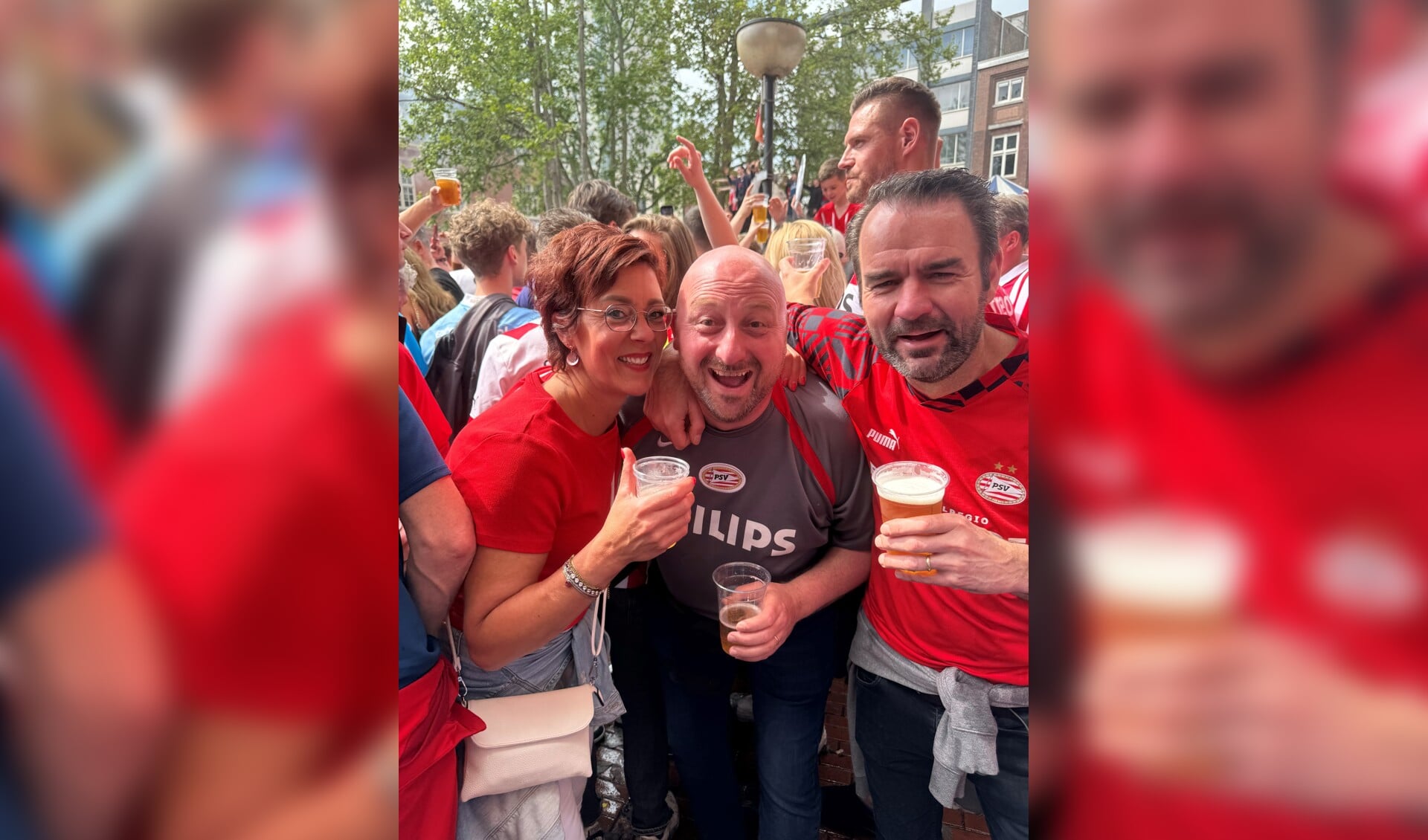 Rob Arts (midden) gaat samen met twee andere PSV-fans, Monique en Mark Nabuurs uit Vierlingsbeek, uit zijn dak in hartje Eindhoven. 