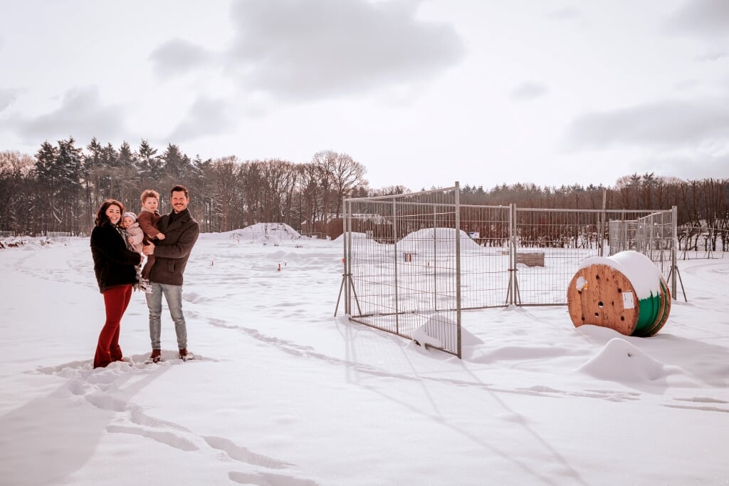Sandro Janssen en Lisa Leupers met hun beide kinderen bij hun toekomstige (onlangs nog winterse) woonplek. . 