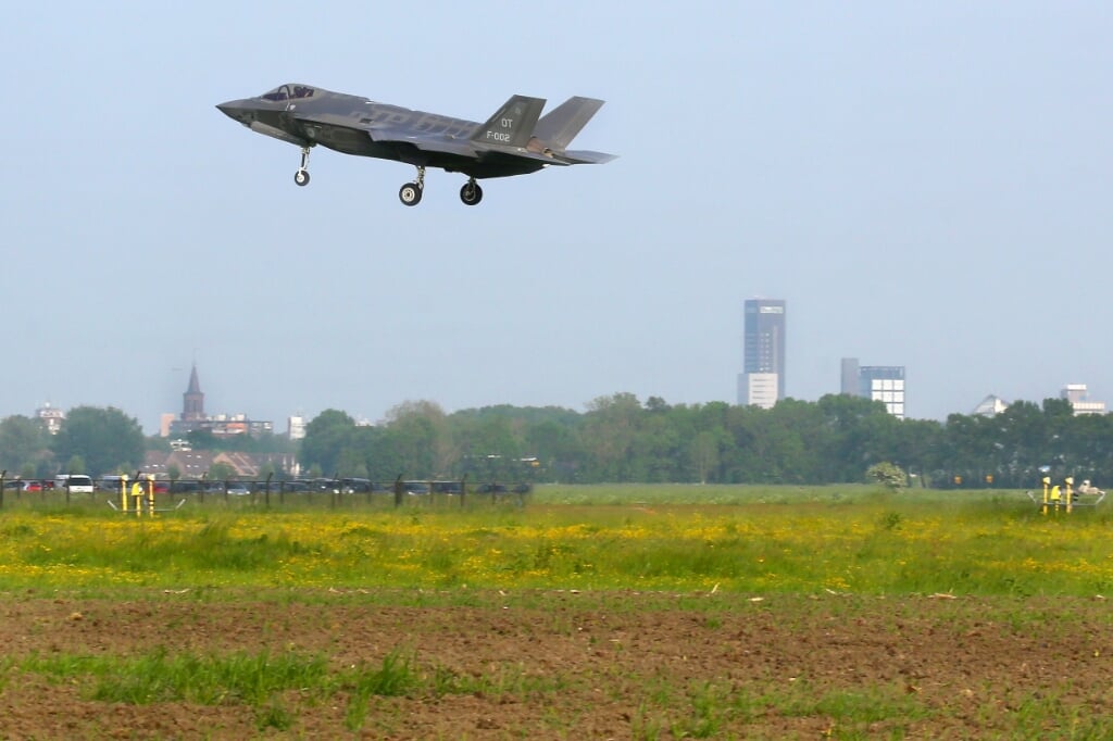 Een F-35 landt op de vliegbasis met op de achtergrond de skyline van Leeuwarden.