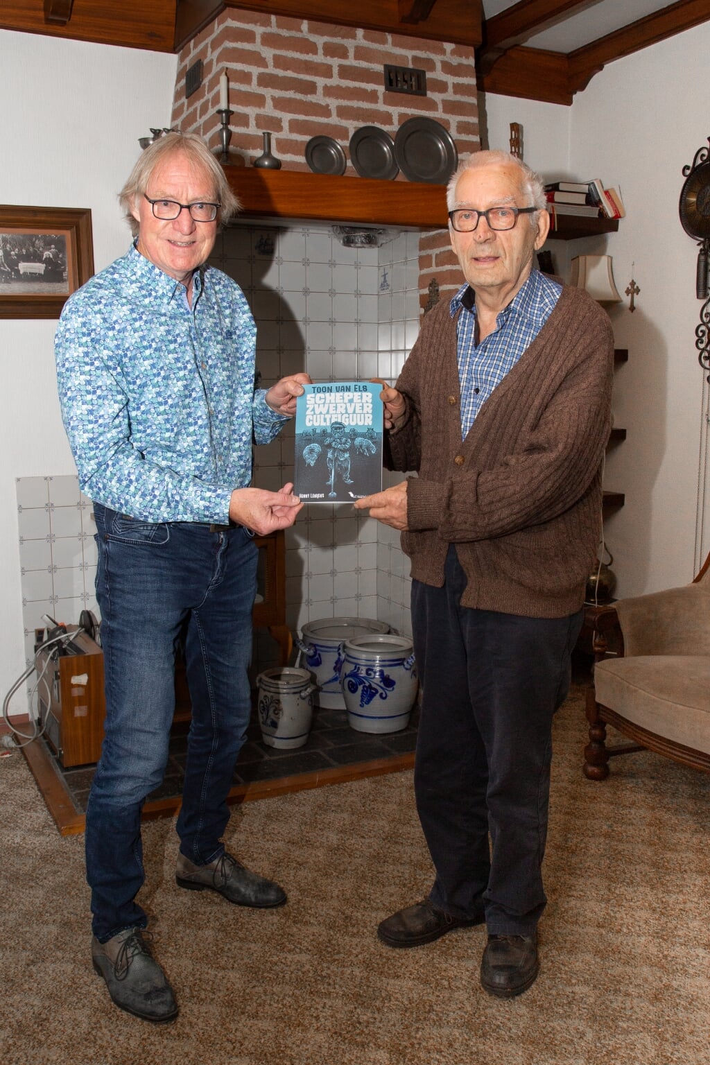 Schrijver Henny Lenkens (links) overhandigt Bèr Rutten de biografie over Toon van Els. 