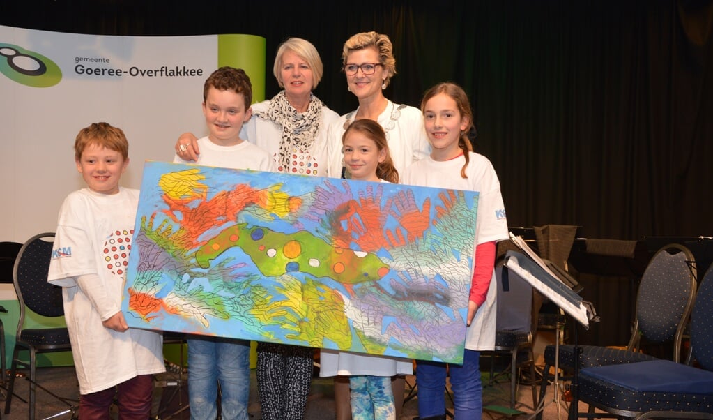 Mees, Marit, Emma en Teun presenteren hun schilderij aan de bezoekers van de nieuwjaarsbijeenkomst. Achter hen Marlies Verda en burgemeester Ade Grootenboer. (Foto: Adri van der Laan.