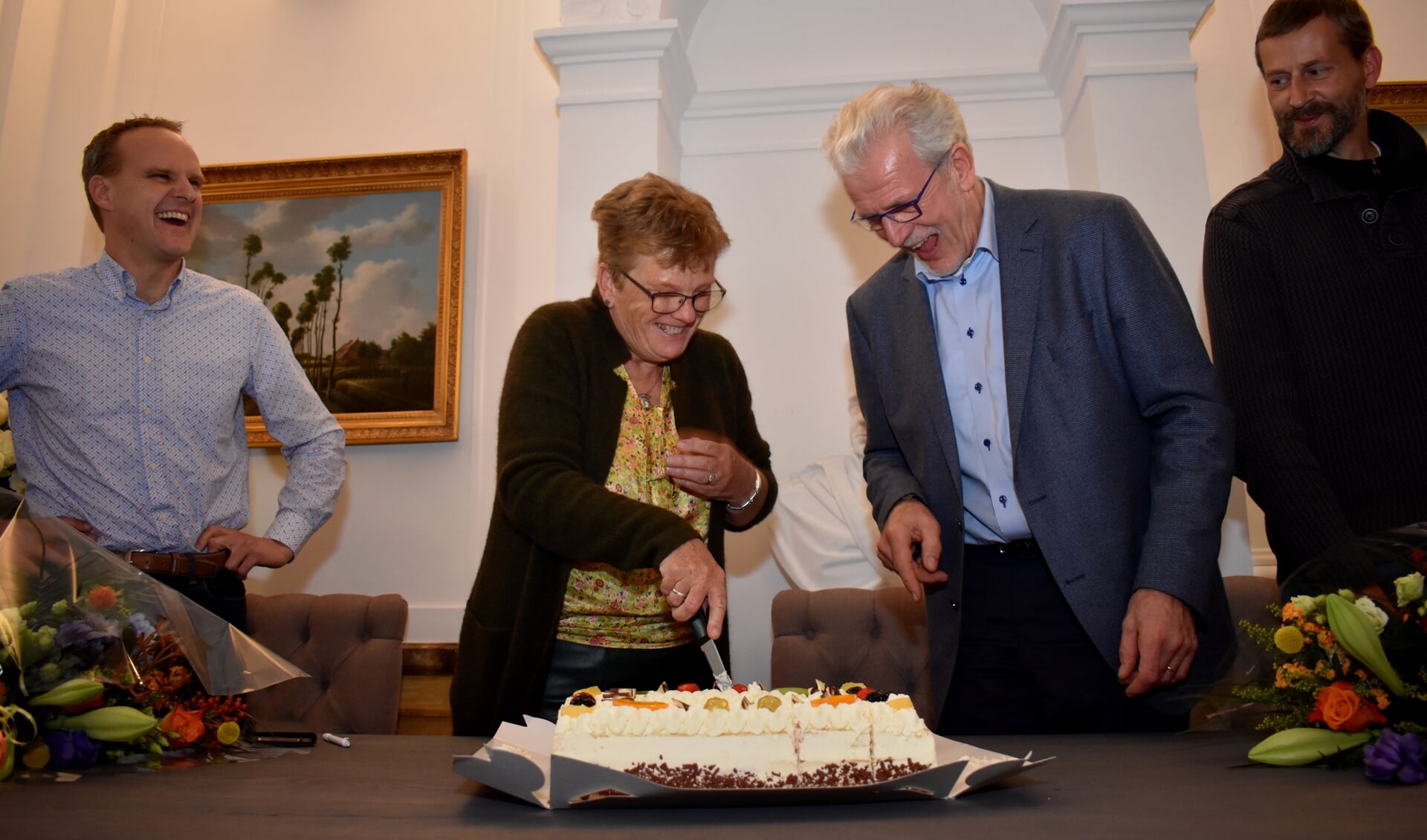 Wethouder Both en Piet Grootenboer snijden met plezier de feesttaart. De ondernemers Franzen (links) en Struik kijken toe.