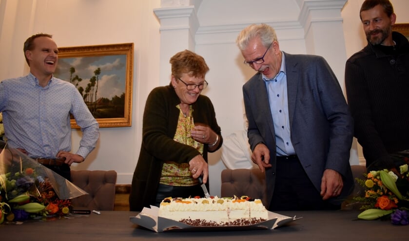 Wethouder Both en Piet Grootenboer snijden met plezier de feesttaart. De ondernemers Franzen (links) en Struik kijken toe.