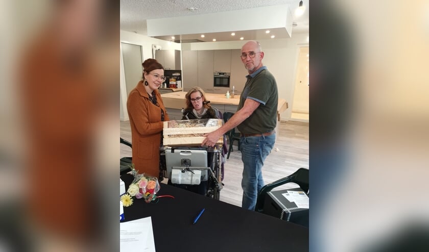 Ook voor Doreen Bergwerff werden de contracten getekend voor haar appartement. Namens Keukencentrum Tieleman overhandigt Corrie de Boed aan elke bewoner, hier aan vader Bergwerff voor zijn dochter, een rijk gesorteerd feestelijk geschenk. Wbv.Beter Wonen schonk een led-verlichtingspakket.
