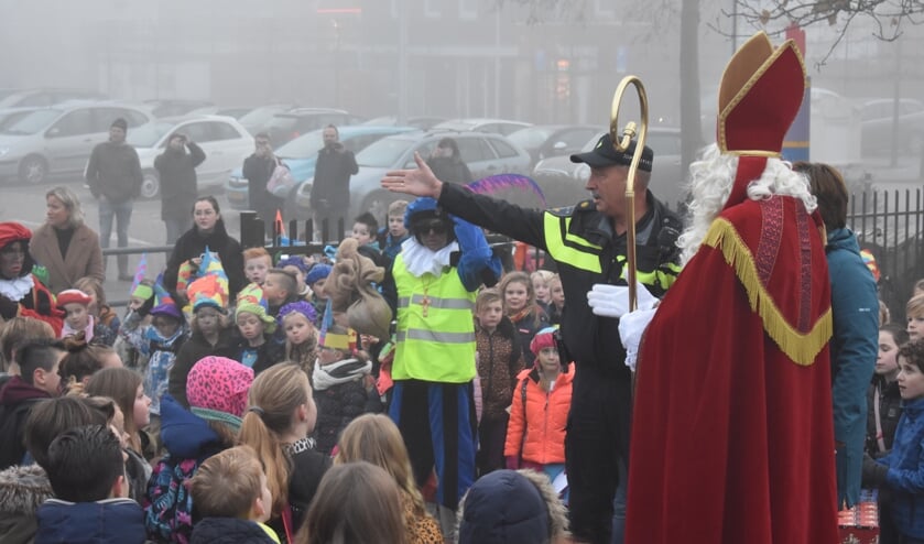 De politieagent vertelt dat de Sint zijn auto verkeerd heeft geparkeerd.