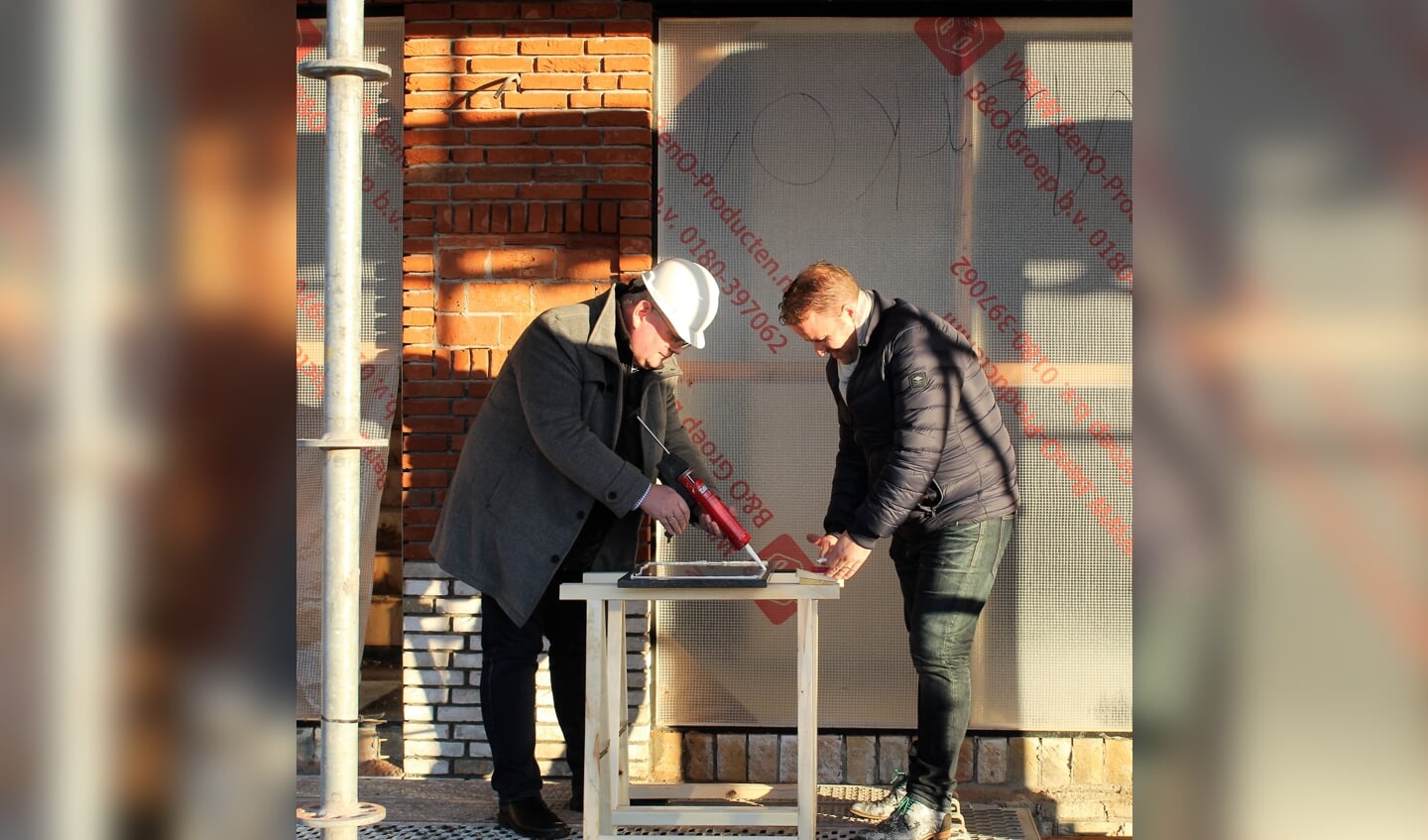 Wethouder Feller en Joris Jansen (Sustay)plaatsen de steen bij de huurappartementen.
