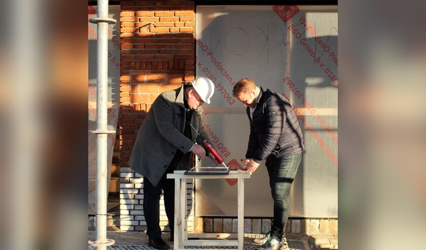 Wethouder Feller en Joris Jansen (Sustay)plaatsen de steen bij de huurappartementen.