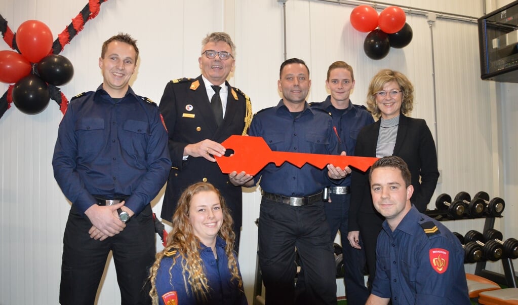 Directeur Veiligheidsregio Rotterdam-Rijnmond Arjen Littoij (in uniform) met in het midden (met rode sleutel) kazernecommandant Mart van de Kreeke en burgemeester Grootenboer (rechts). De overige vier personen zijn de beroepsbrandweermensen die de post bemannen.