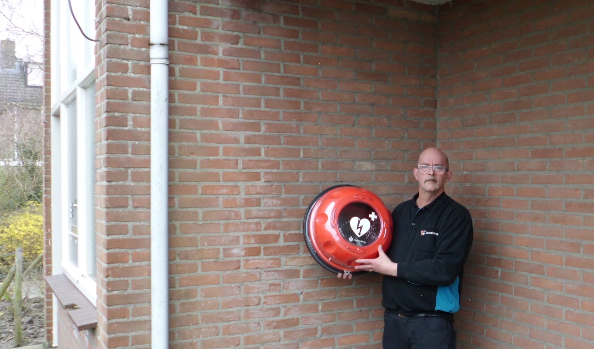 Gerard Barendse bij de seniorenwoningen aan het Lincolnplein, met de AED voor de Grutterswei.
