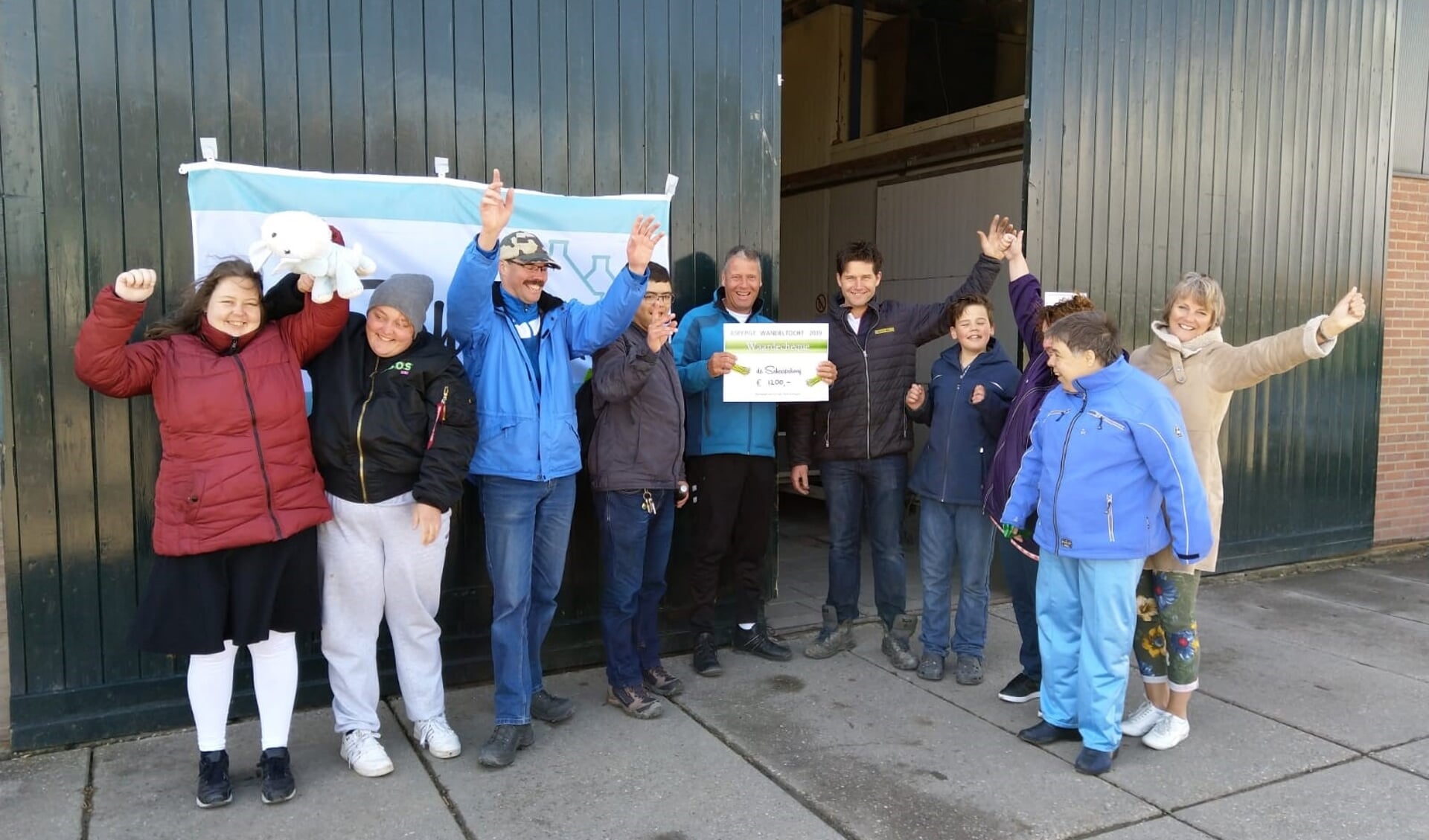 Jabin van der Velde overhandigt de cheque aan fam. Kooijman.