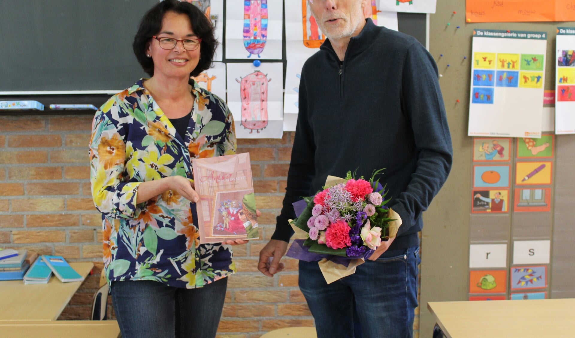 Elly Doornbosch overhandigt het boek aan directeur Cor Both en hij geeft bloemen aan Elly.