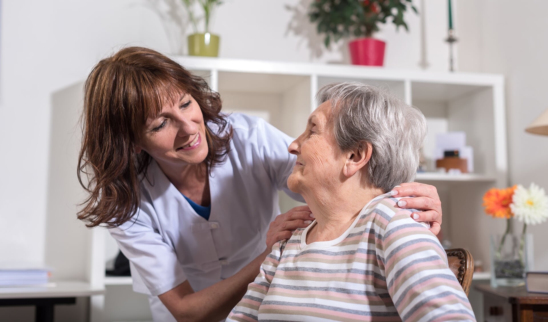 Nurse with her hands on the shoulder of a senior woman