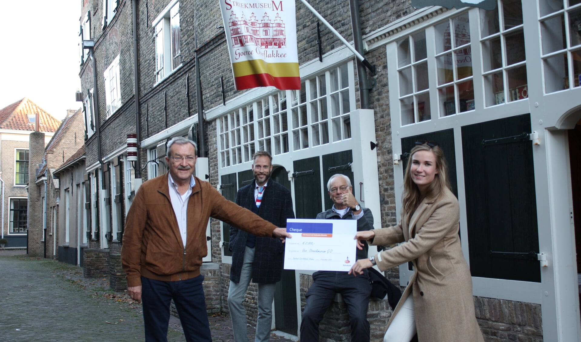 Marjolein Buth overhandigt de cheque aan de bestuursleden (v.l.n.r.) Kalle, Van den Boogert en Schuring (Foto: Kees van Rixoort).