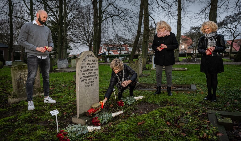Burgemeester Grootenboer plaatst het kaarsje bij het oorlogsgraf, in het bijzijn van de nichtjes van de overleden broertjes De Bruin en voorzitter Dennis Notenboom van de stichting WO2GO (Foto: Wim van Vossen).