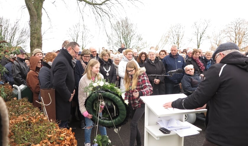 Twee leerlingen van De Bron leggen een krans tijdens de herdenking van de Watersnoodramp in Oude-Tonge (Foto: Mirjam Terhoeve).