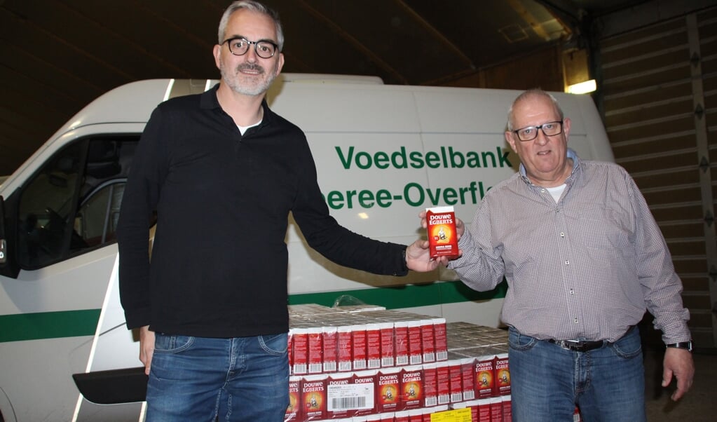 President van de Lions Club Goeree-Overflakkee, David Jaap Goekoop (l), overhandigt aan Martin Ista, vrijwilliger bij de voedselbank, 1.570 pakken DE koffie. Martin Ista van de voedselbank sorteert en telt de punten.