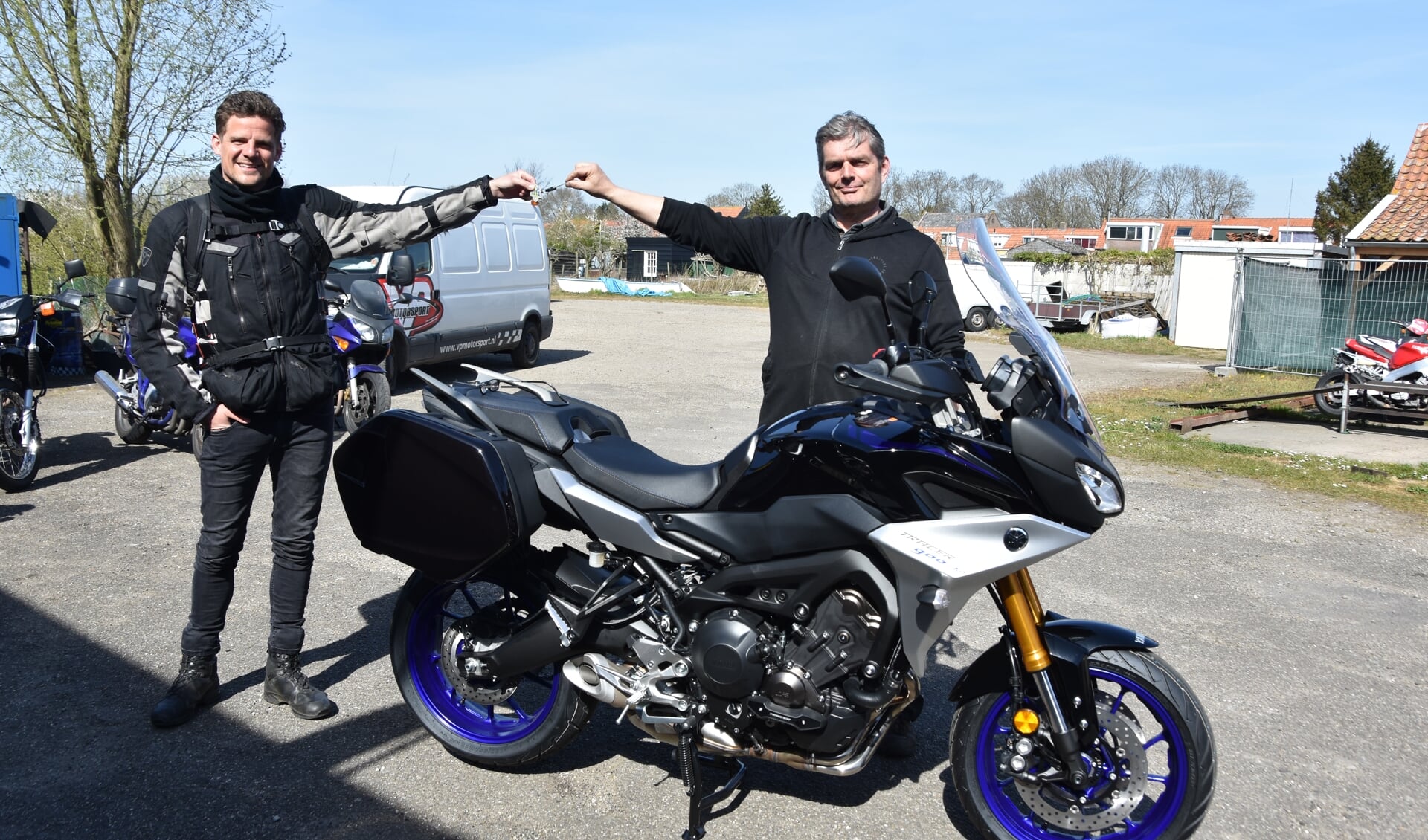 Veldwerker Gerwin Rikkers (links) ontvangt - op gepaste afstand - de sleutels voor de nieuwe motor van Wilco Visser.