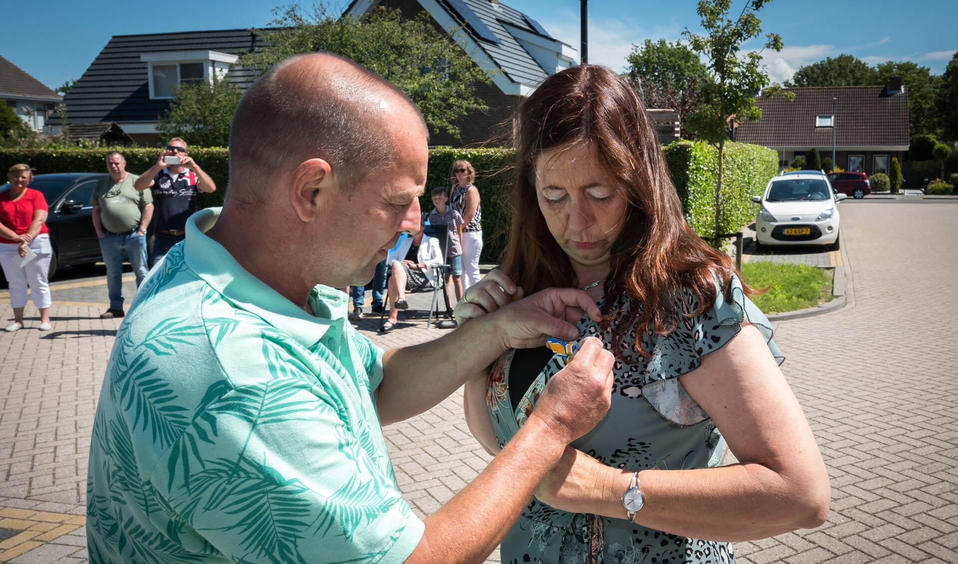 Caroline Struijk krijgt haar lintje opgespeld door haar man (Foto: Wim van Vossen).