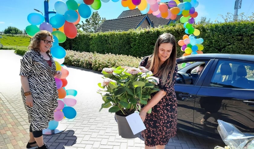 Marleen Koppert (links) werd overladen met cadeautjes tijdens de drive-through afscheidsreceptie.