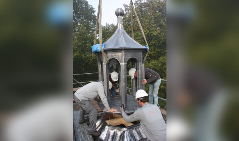 De nieuwe torenspits wordt op zijn plaats bevestigd (Foto: Kees van Rixoort).