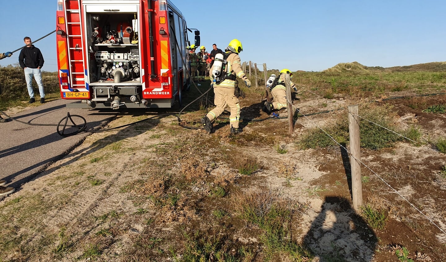 Ook met tankwater uit de brandweerauto gaat men in de duinen het vuur te lijf (Foto Jaap Ruizeveld).