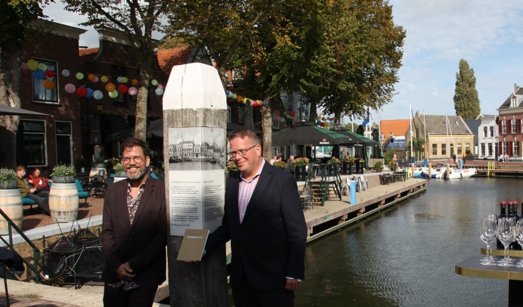 Bart Prinsen (links) overhandigt het eerste exemplaar van zijn dichtbundel aan wethouder Bruggeman (Foto: Klazina de Bakker).