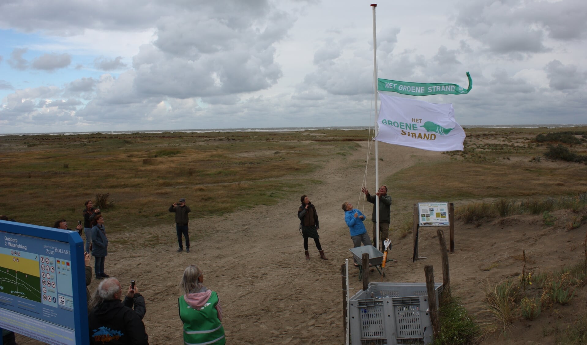 Wethouder Tea Both hijst de Groene Strand Wimpel met bijbehorende vlag (Foto: Kees van Rixoort).