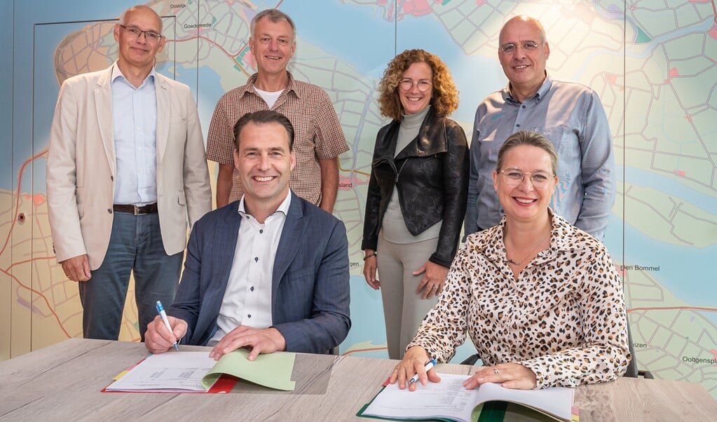Ondertekening van de overeenkomst door Marleen van de Kamp (Oost West Wonen) en Ivo Zweekhorst (Kroon & De Koning). Staand op de foto van links naar rechts: René Kom (Kroon & De Koning), Andre Smits, Petra van der Waal-Kom en Kees van Dam.