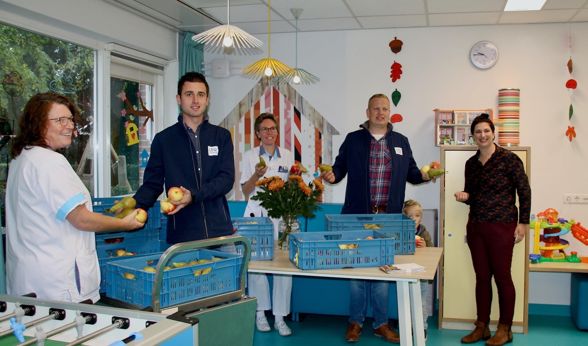 Niels van Nederpelt en Pieter van Kempen van LTO Noord, afdeling Goeree-Overflakkee overhandigen het fruit aan het ziekenhuispersoneel. De dame in het midden is zorgcoördinator Karin van Tigchelen (Foto: Klazina de Bakker).