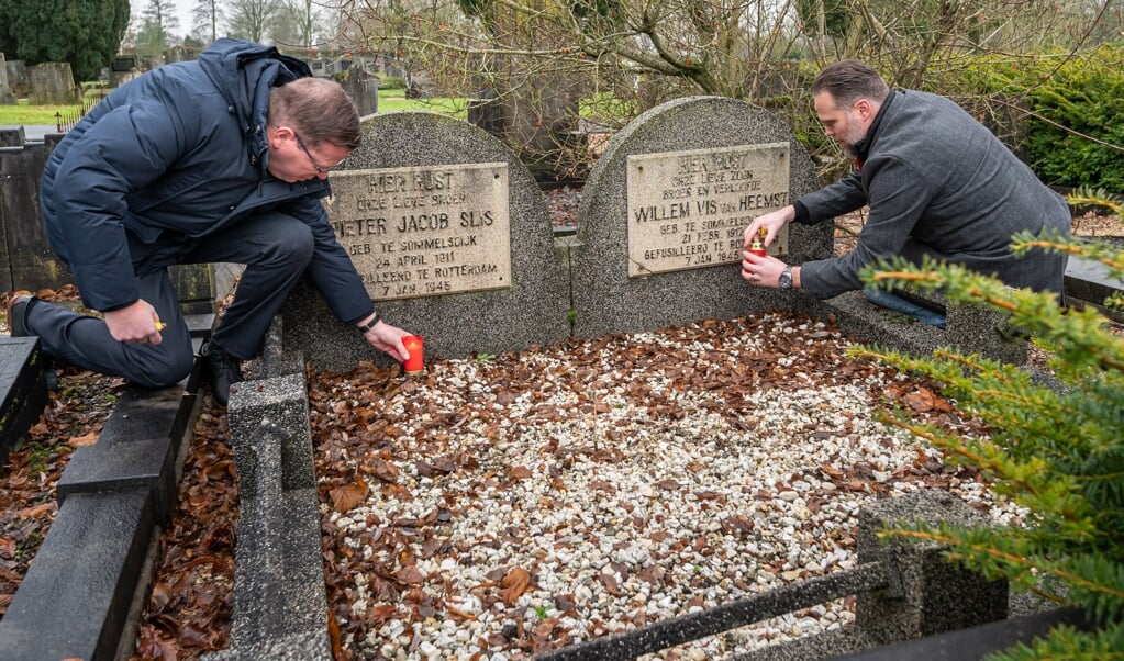 Wethouder BerendJan Bruggeman en Matthijs Guijt zetten een kaarsje bij de oorlogslachtoffers op de begraafplaats in Sommelsdijk (Foto: Wim van Vossen).