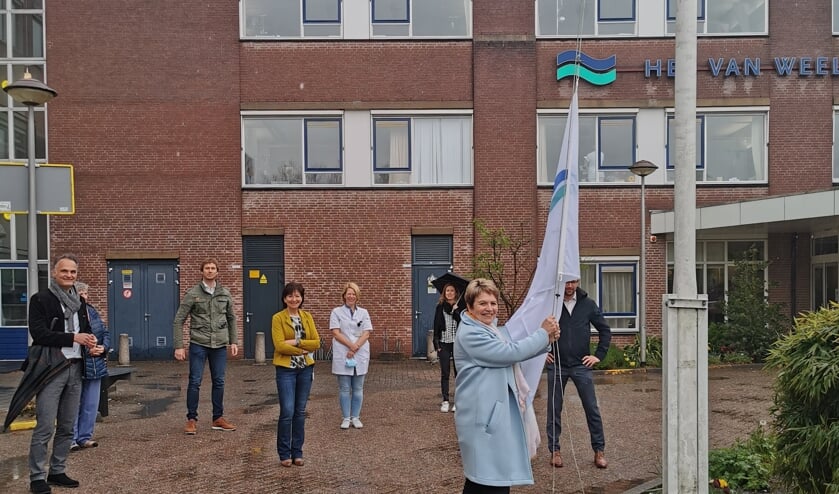 <p>Afdelingshoofd Désirée Luijten hijst symbolisch de vlag. (Foto: CuraMare)</p>