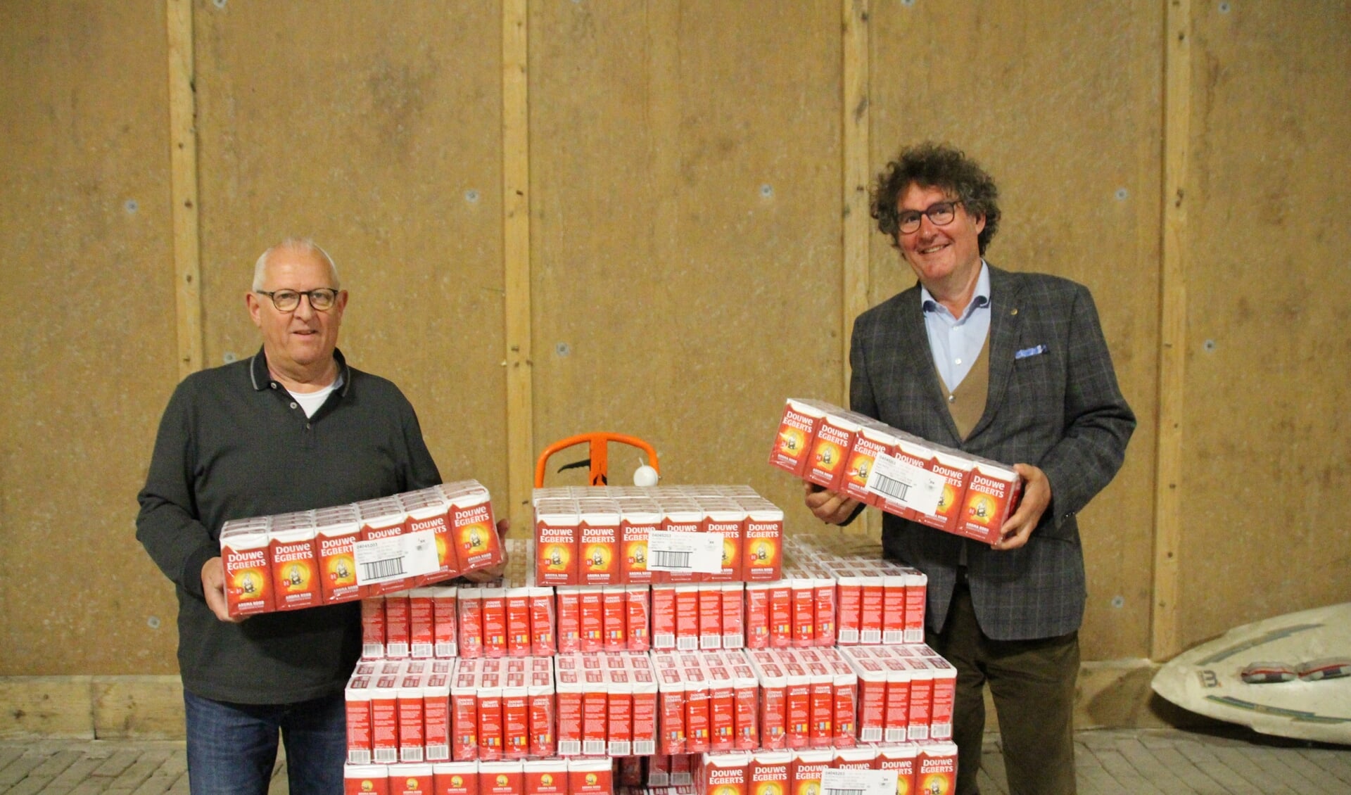 President van de Lions Club Goeree-Overflakkee, Toon Meeuwsen (r), overhandigt aan Martin Ista, vrijwilliger bij de voedselbank, 1.200 pakken DE koffie.