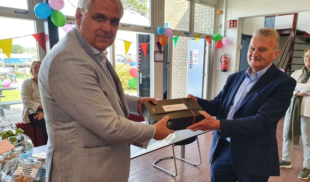UFA-directeur Van Nieuwenhuijzen overhandigt een cadeau aan Henk Redert.