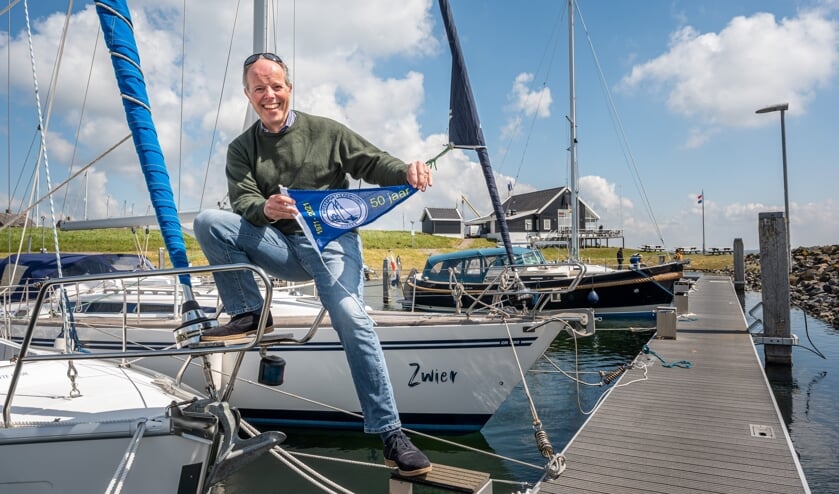 <p>Voorzitter Frederik van der Dussen van WSV Goeree met het jubileumvlaggetje in de Ouddorpse haven (Foto: Wim van Vossen).</p>
