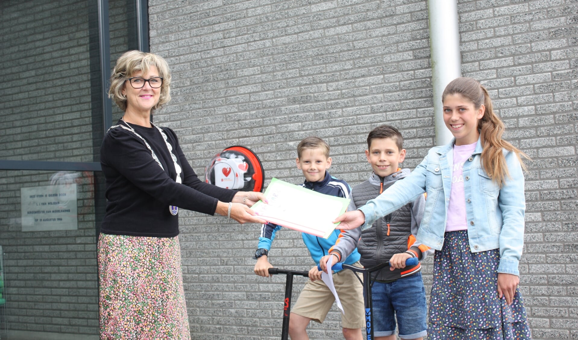 Burgemeester Ada Grootenboer neemt de handtekeningen in ontvangst van Laurens, Tom en Daniëlle (Foto: Kees van Rixoort).