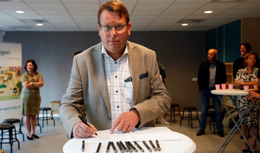<p>Wethouder Berend Jan Bruggeman zet zijn handtekening (Foto: John de Pater).</p>