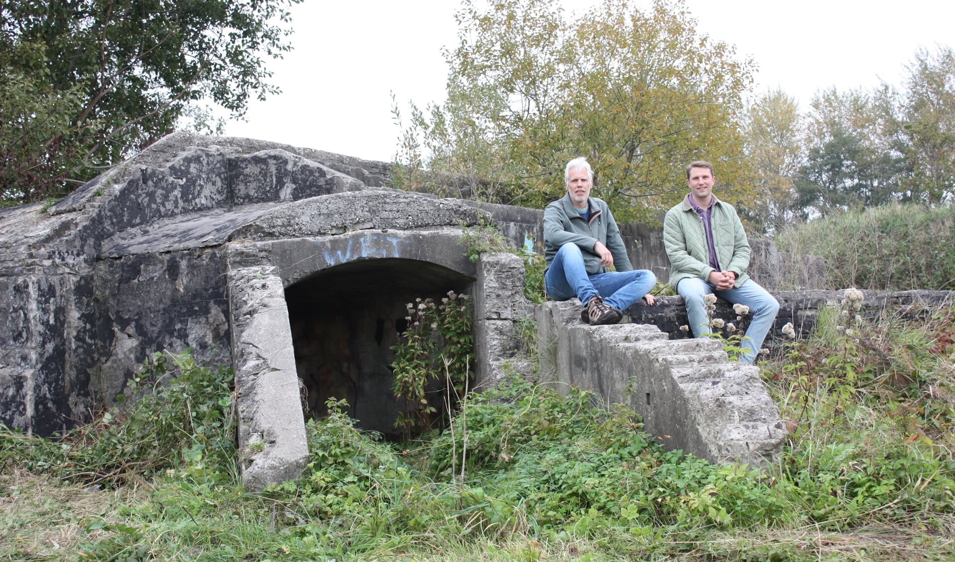 Jeroen Rijpsma (links) en Arthur van Beveren bij de toegang tot een van de bunkers aan de Hofdijksweg (Foto: Kees van Rixoort).