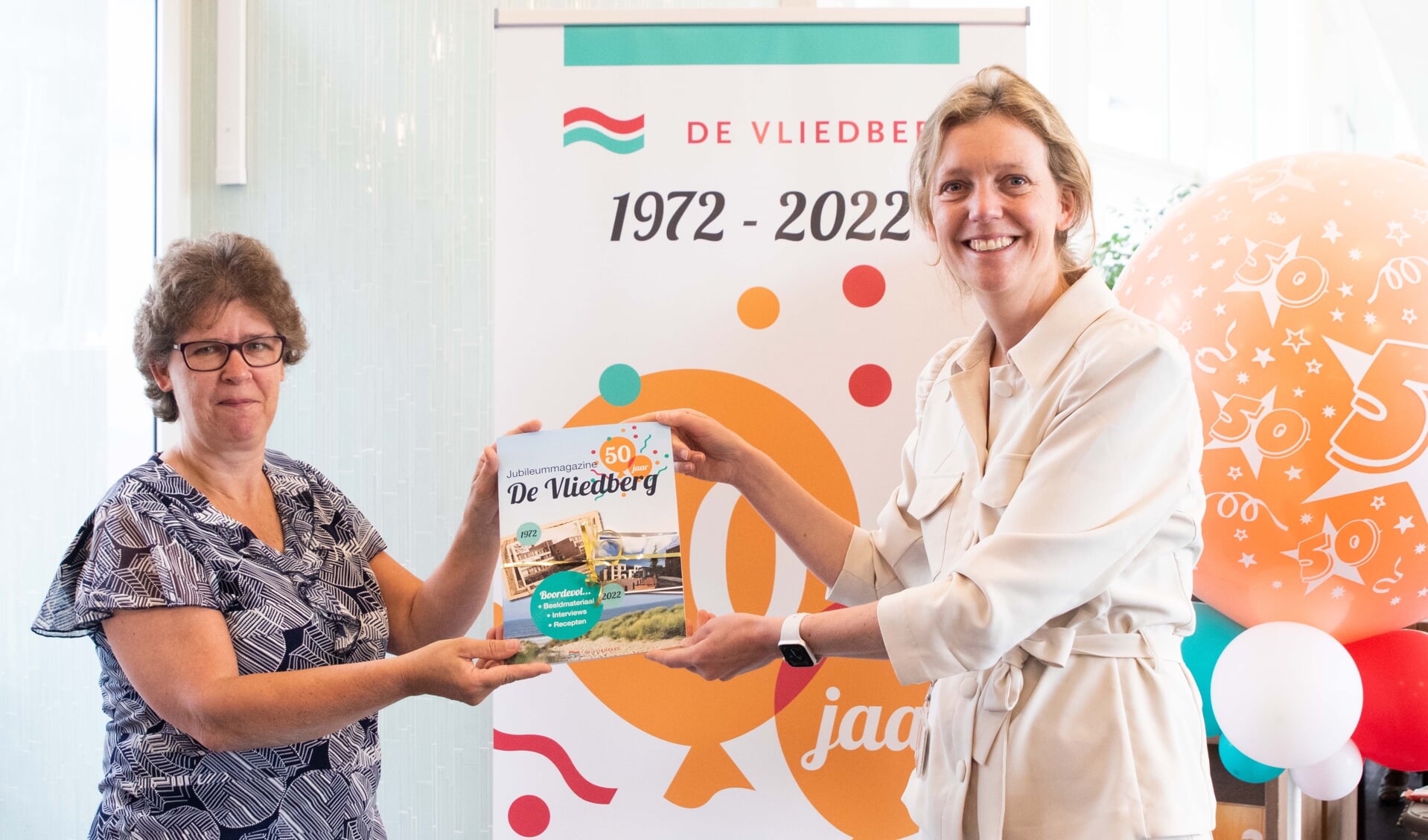 Op de foto: Ellen Hoogervorst –van der Meer (rechts) overhandigt het jubileummagazine aan Clarie Tanis (links)