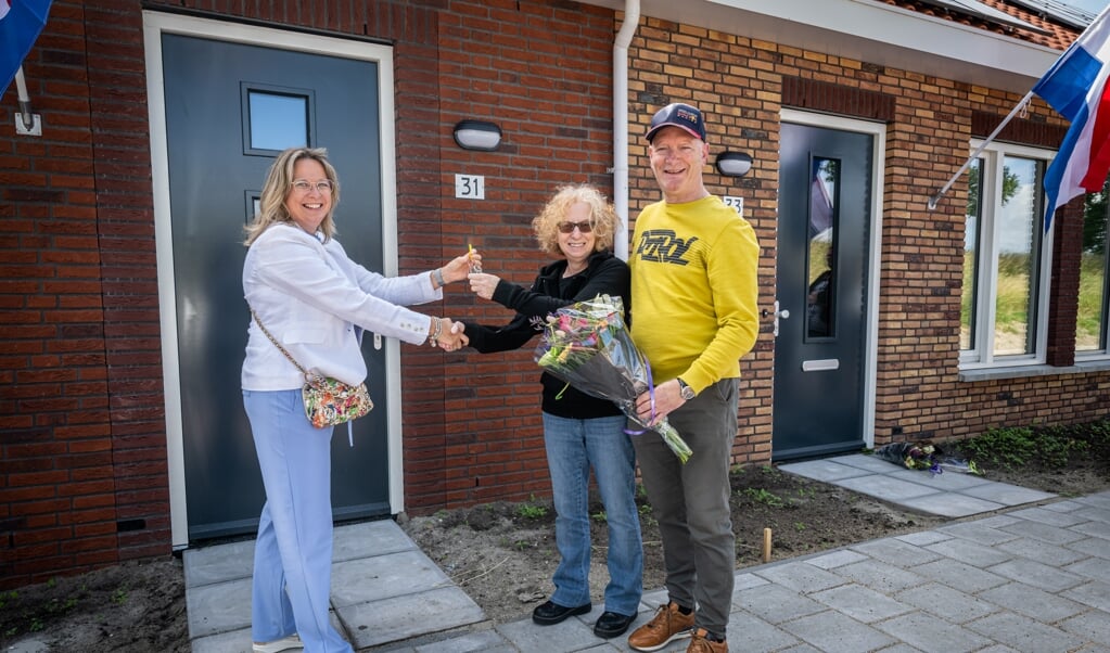 Marleen van de Kamp, directeur-bestuurder Oost West Wonen, overhandigt eerste sleutel aan huurders. (Foto: Wim van Vossen )