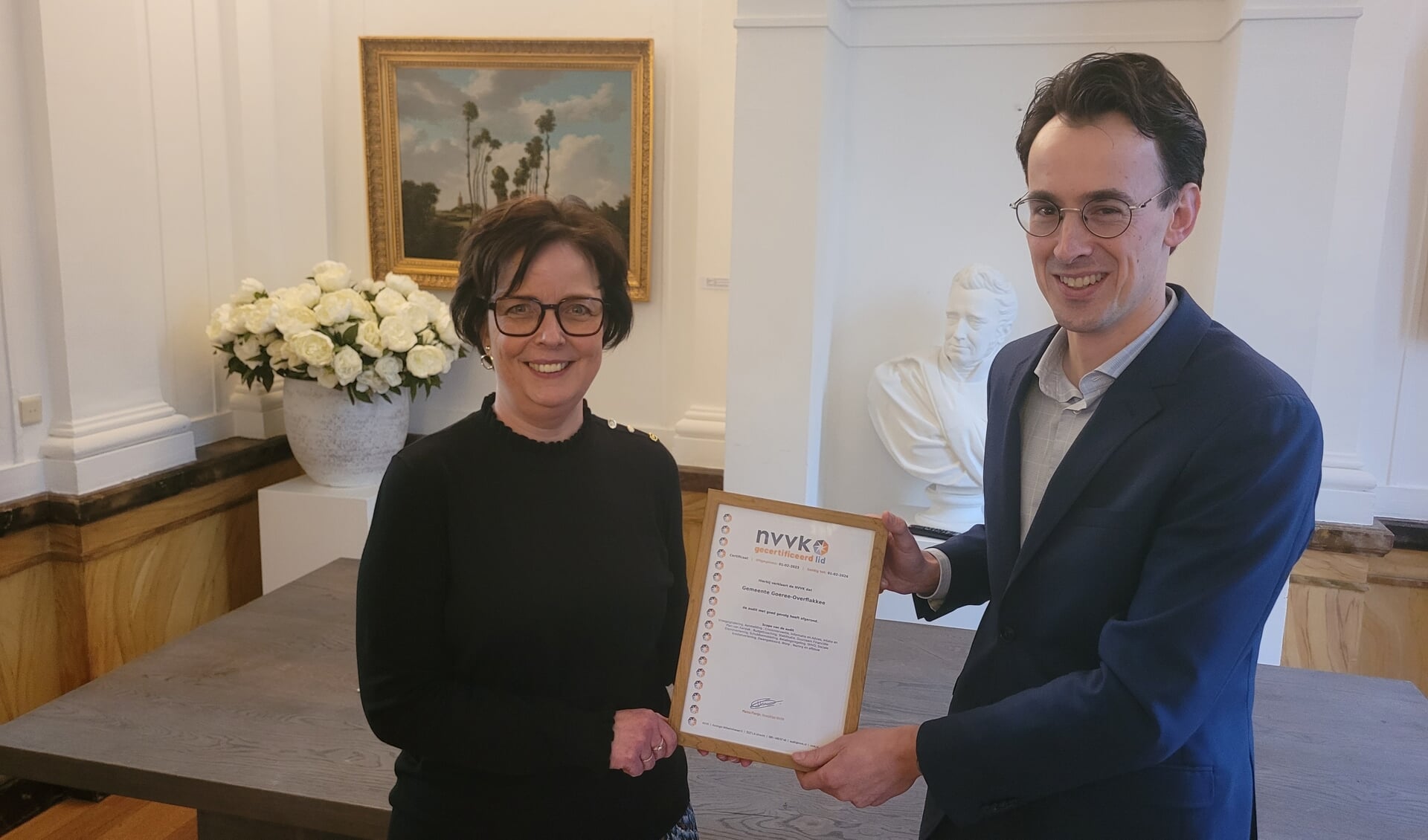 Joeri Eijzenbach van de NVVK overhandigt het NVVK-certificaat aan directeur Arianda Phaff van gemeente Goeree-Overflakkee. 