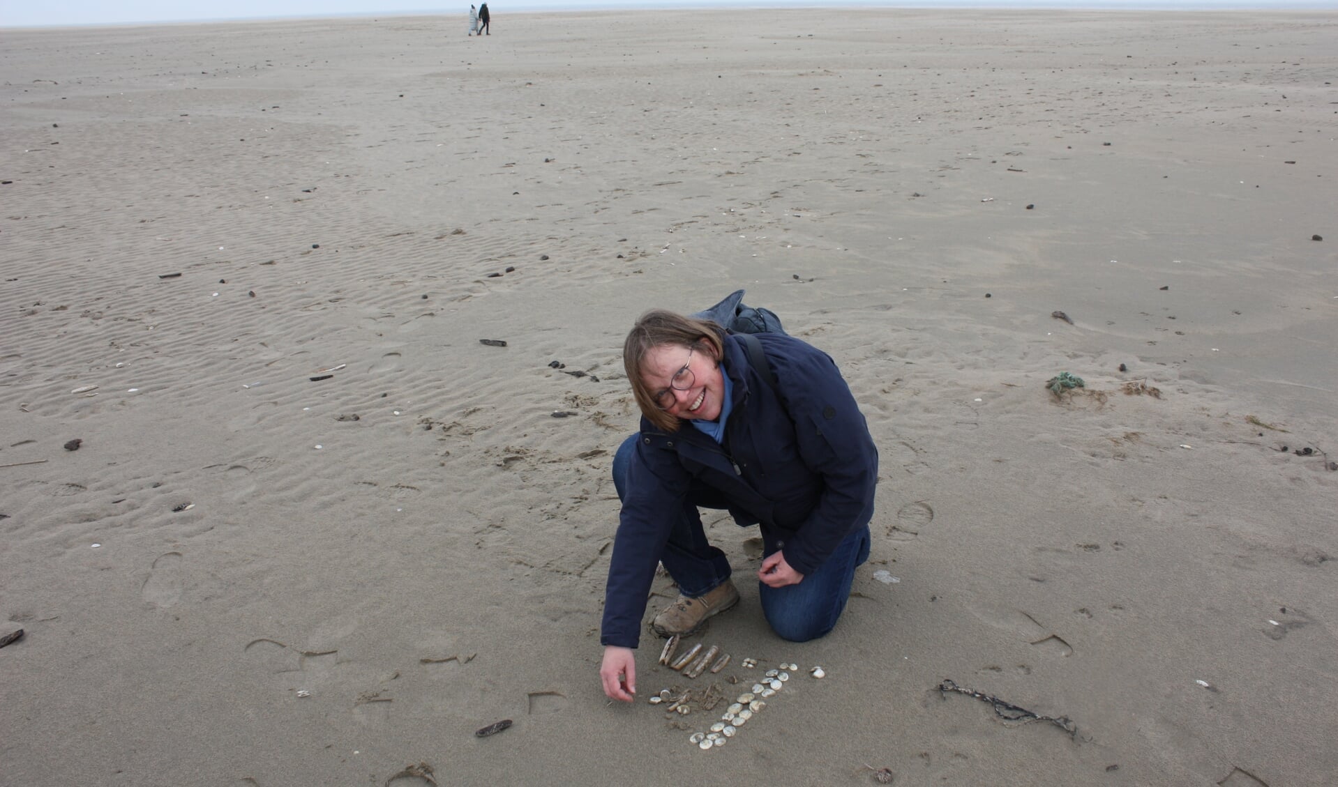 Katie van der Wende sorteert de schelpen die ze gevonden heeft.