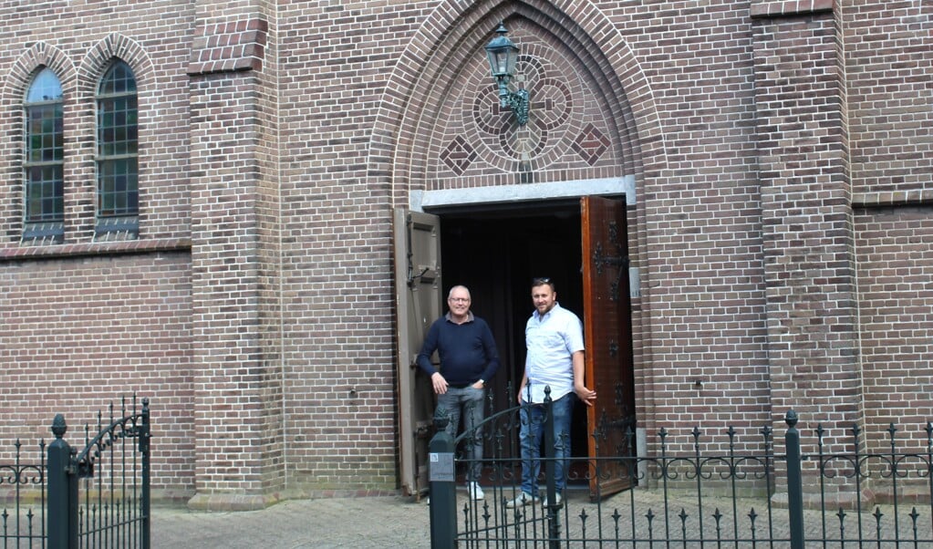 Organist Ron Braber en koster Tim Jochems bij de ingang van de kerk.