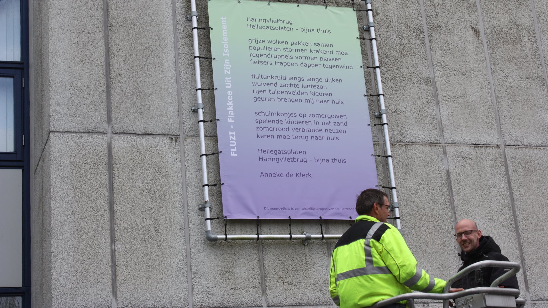 Het FLUZI-gedicht is zojuist bevestigd op de gevel van het gemeentehuis. (Foto: Kees van Rixoort)