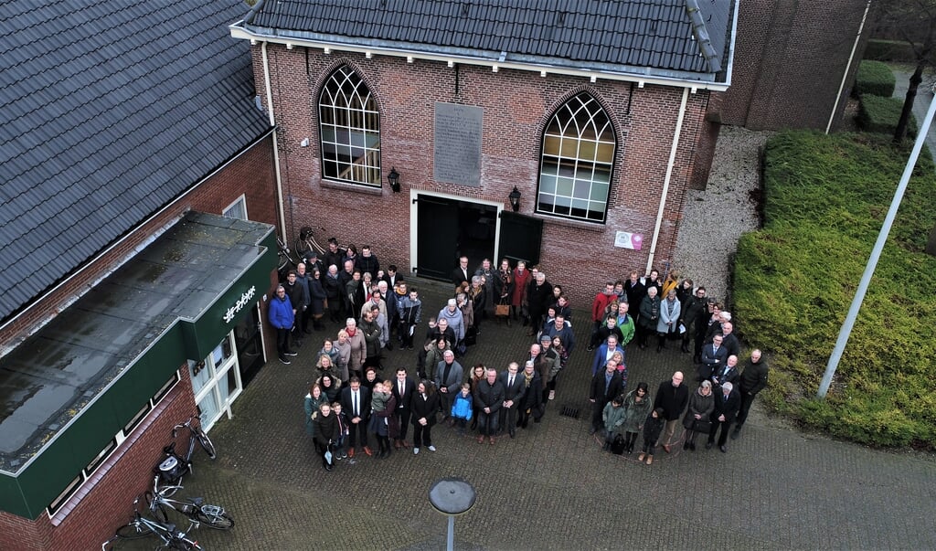 Leden van de hervormde kerk vormen het getal 200 op het kerkplein.