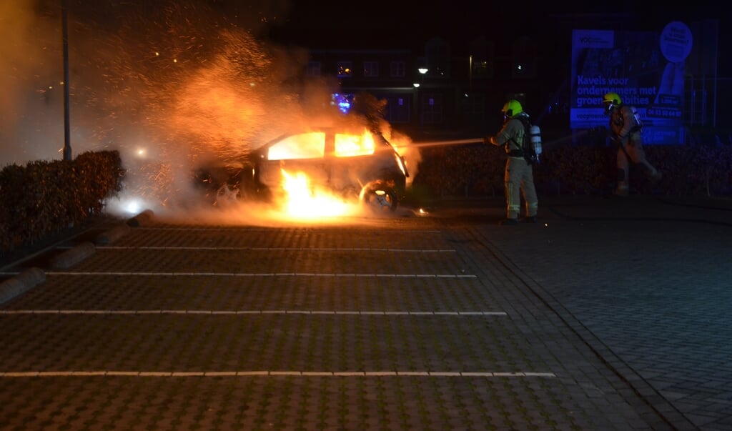 De brandweer blust de brandende auto aan de Rottenburgseweg in Middelharnis.