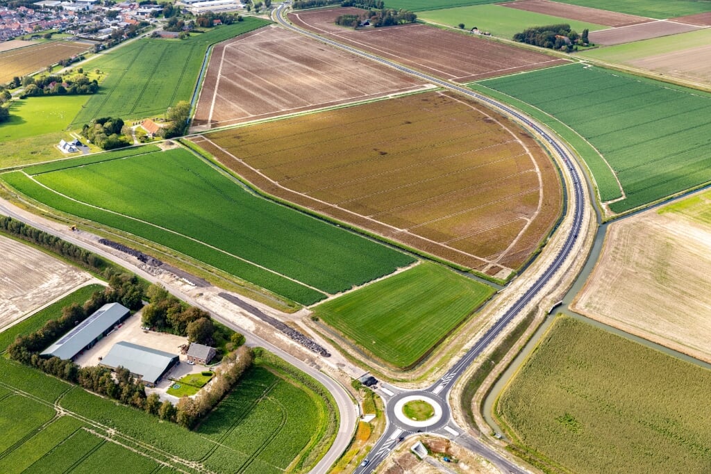 Links de parallelweg die voor de vertraging zorgt, rechts het nieuwe deel van de N215 tussen Melissant en Dirksland. Inzet: de rotonde het nieuwe fietstunneltje (Foto's: Topview Luchtfotografie)