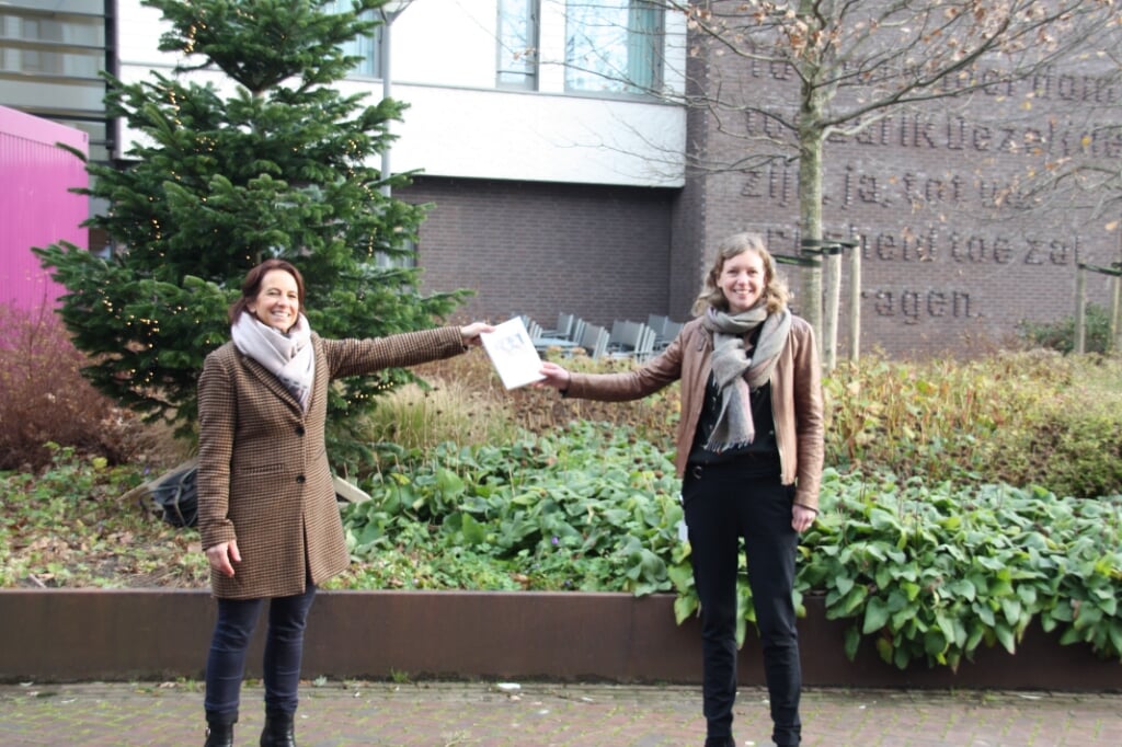 Maria Vroegindeweij (links) overhandigt het eerste exemplaar van haar boek aan Elle Hoogervorst van de raad van bestuur van CuraMare (Foto: Klazina de Bakker).