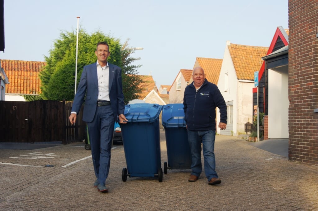 Wethouder Markwat en Webego-medewerker Wim van Moort in 2017 met de blauwe container in Ouddorp. 